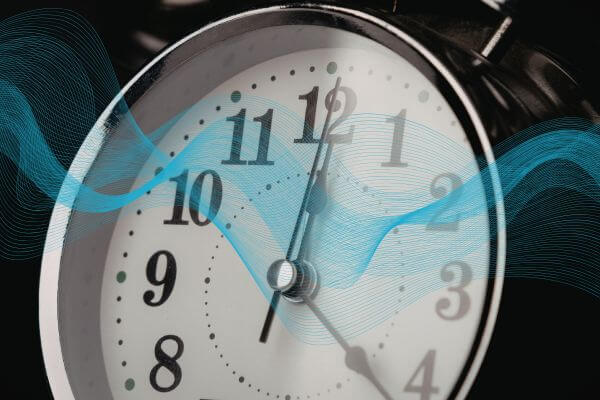 Alarm clock with a stylized blue wave effect on a dark background