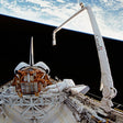 Space shuttle with robotic arm against a space backdrop