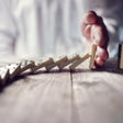 hand stopping falling dominos