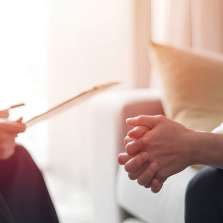 Two people holding hands with a blurred background