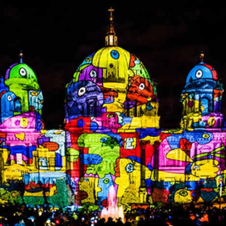 Colorful illuminated sculpture of a building with a dark background