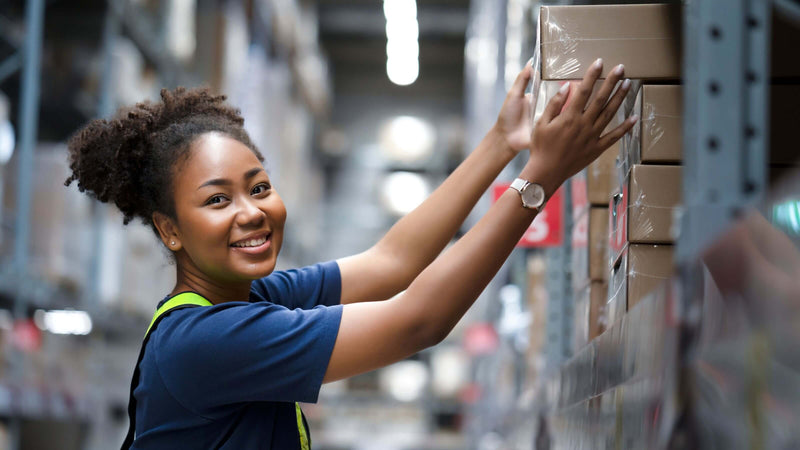 female warehouse worker stacking boxes