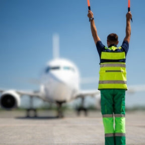 Worker directing an airplane on a runway