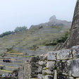 Machu Picchu with stone walls and terraced fields on a foggy day