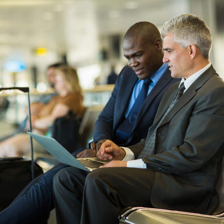 business travelers at airport looking at laptop